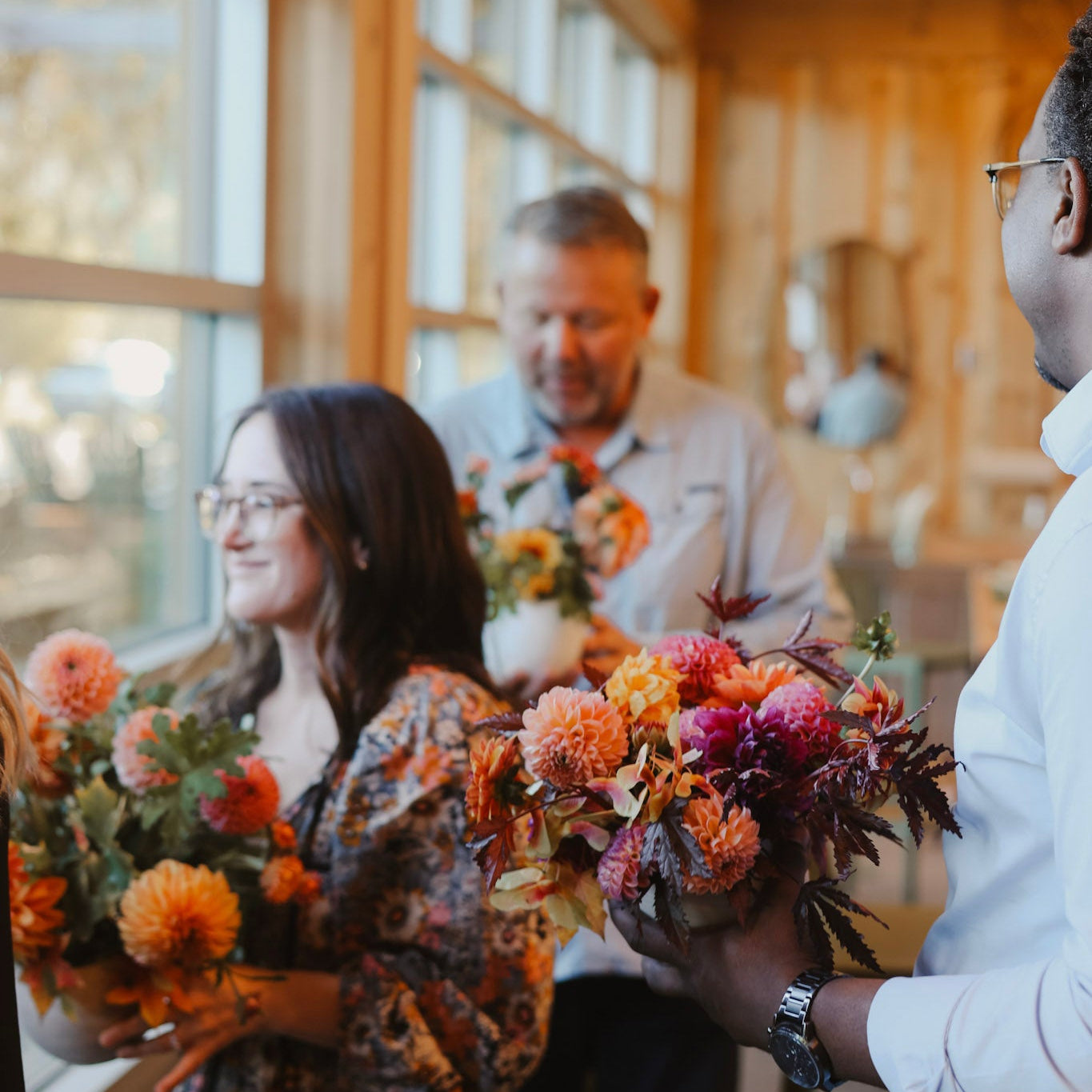 Corporate guests during a floral design workshop holding flower arrangements made at the Flower Porch studio.