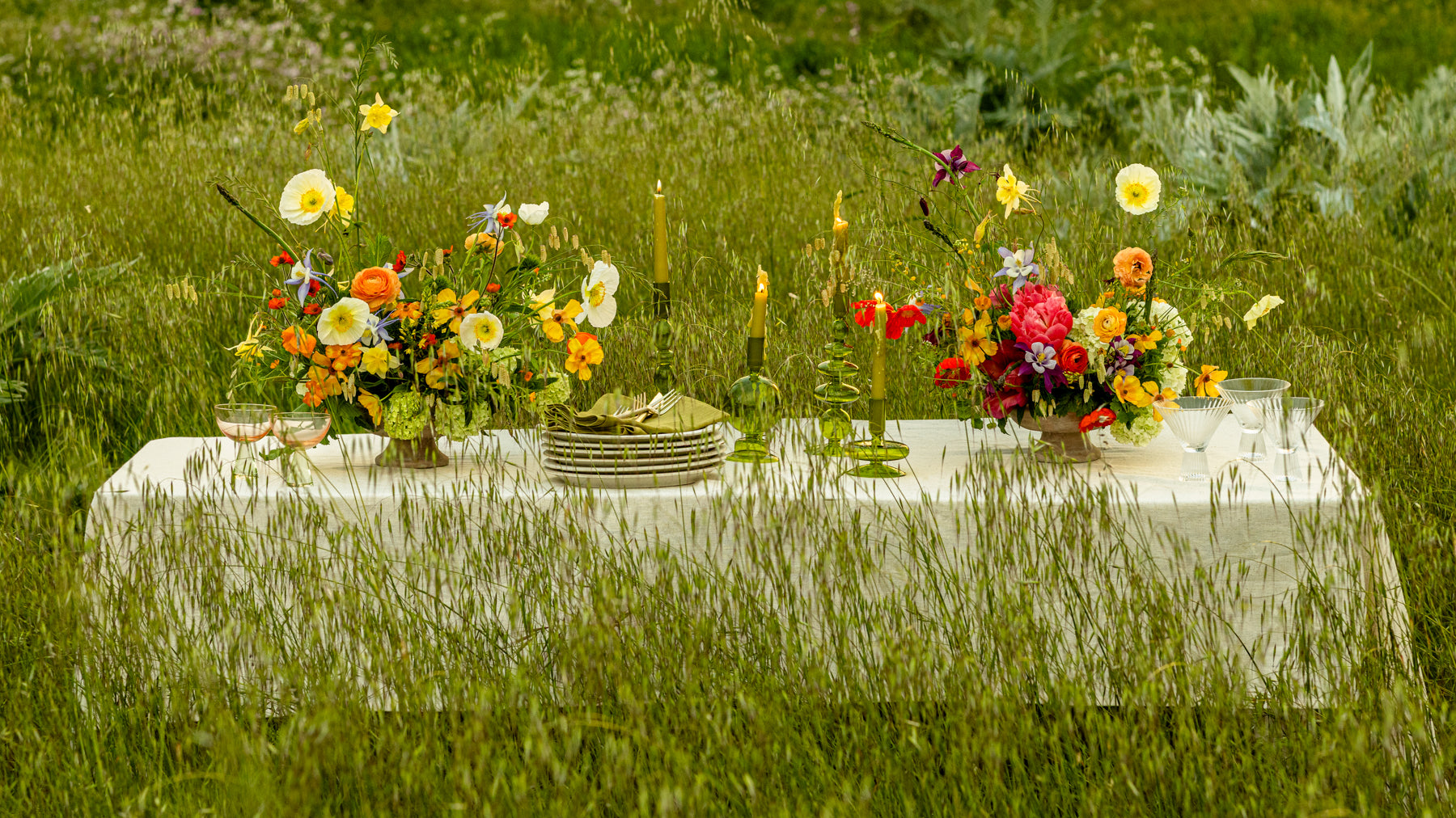 Elevated floral design on a table setting at Front Porch Farm using all organic flowers in a grassy field.