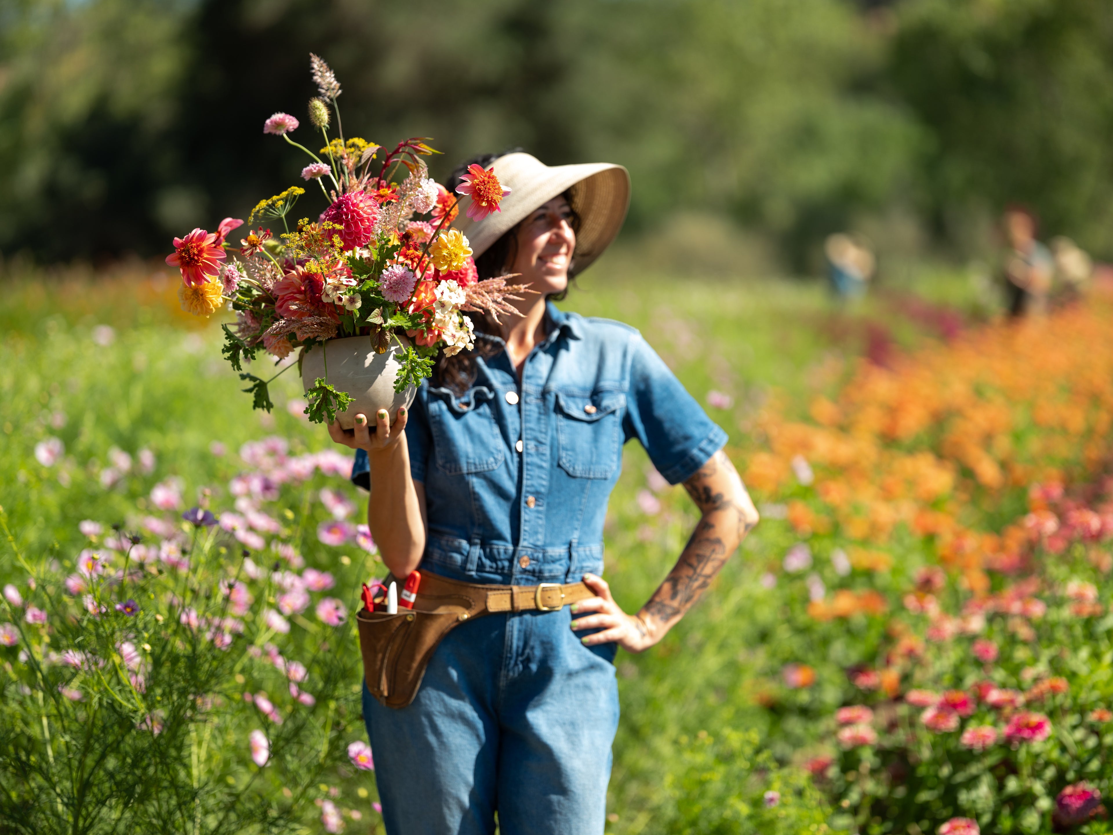 Creative Director, Jaclyn holding an arrangement  of flowers in a field at Front Porch Farm.